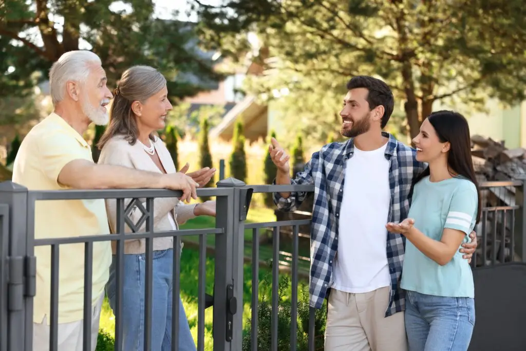 Friendly,Relationship,With,Neighbours.,Young,Family,Talking,To,Elderly,Couple