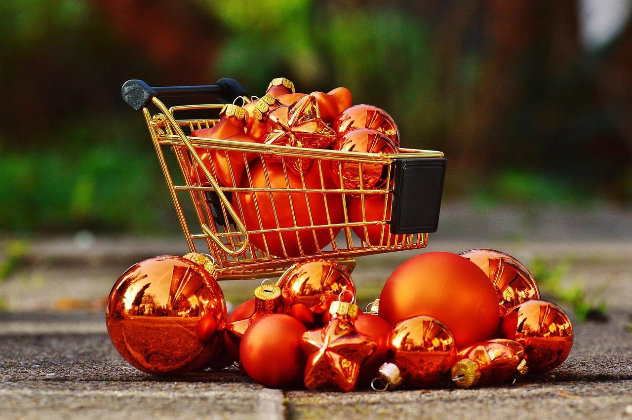 "Mini shopping cart filled with Christmas ornaments, symbolizing seasonal demographic intelligence that helps marketers target holiday shoppers by income, life stage, and purchase behavior.
